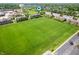 Expansive aerial view showcasing a green field near a brick townhouse development at 3546 Golden Gate N Dr, Carmel, IN 46074