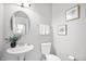 Stylish powder room with pedestal sink, round mirror, neutral colors, and elegant decor at 3546 Golden Gate N Dr, Carmel, IN 46074