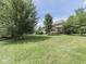 Large backyard with mature trees offering ample shade, a well-maintained lawn, and landscaping at 3601 Lakeshore Ct, Greenwood, IN 46143