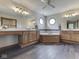 Large bathroom with dual vanities, soaking tub, wood cabinets, and stylish mirrors at 3601 Lakeshore Ct, Greenwood, IN 46143
