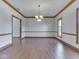 Empty dining room featuring wood trim, wood floor and modern light fixture at 3601 Lakeshore Ct, Greenwood, IN 46143