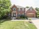 Charming two-story brick home featuring a landscaped yard, attached garage, and inviting entrance at 3601 Lakeshore Ct, Greenwood, IN 46143