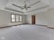 Spacious main bedroom features a tray ceiling with fan, large window, and neutral carpeting at 3601 Lakeshore Ct, Greenwood, IN 46143