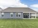 Spacious backyard with lush green grass and a covered patio seating area for relaxation at 3697 Chalmers Dr, Bargersville, IN 46106