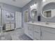 Modern bathroom with double sinks, white cabinets, two mirrors, and elegant light fixtures at 3697 Chalmers Dr, Bargersville, IN 46106