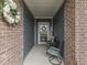 Cozy front porch with stylish seating, wreath, and brick accents, creating an inviting entryway at 3697 Chalmers Dr, Bargersville, IN 46106