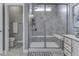 Luxurious shower with gray tiling, glass door, built-in bench, and small window for natural light at 3697 Chalmers Dr, Bargersville, IN 46106