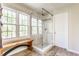 Bright bathroom featuring a glass enclosed shower, large windows, and a wooden bench at 3808 Brigade Cir, Carmel, IN 46032