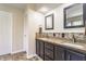 Bathroom featuring dual sinks, dark cabinetry, a decorative backsplash and updated tile flooring at 3808 Brigade Cir, Carmel, IN 46032