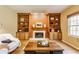 Warm living room featuring built-in bookshelves, a fireplace, and comfortable seating at 3808 Brigade Cir, Carmel, IN 46032