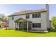Spacious backyard featuring an enclosed porch and neutral siding with a well-maintained lawn and blue sky at 3808 Brigade Cir, Carmel, IN 46032