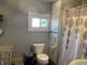 Bright bathroom with window, featuring a standard toilet and shower with patterned curtain at 40 N Park Ave, Martinsville, IN 46151