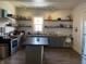 Bright kitchen with gray cabinets, an island, and open shelving for storage at 40 N Park Ave, Martinsville, IN 46151