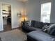 Comfortable living room featuring a gray sectional sofa and view into the kitchen at 40 N Park Ave, Martinsville, IN 46151