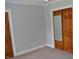 A bedroom is bright with carpeted floors, crown molding, and a sliding door closet space at 4736 Madison Ave, Indianapolis, IN 46227