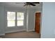 A bright bedroom boasts a ceiling fan, neutral paint, carpeted floor, with natural light from windows at 4736 Madison Ave, Indianapolis, IN 46227