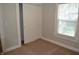A quaint bedroom with fresh paint, carpet, bright light, and sliding closet doors at 4736 Madison Ave, Indianapolis, IN 46227