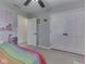 Colorful bedroom with ceiling fan and door to hall, closet, floral wall decorations at 4759 Silver Hill Dr, Greenwood, IN 46142