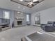 Spacious living room featuring a fireplace, tray ceiling, and seamless transition to dining area at 4759 Silver Hill Dr, Greenwood, IN 46142