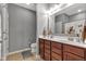 Bright bathroom featuring a double vanity, ceramic tile flooring, and a shower at 4809 Ozark Ln, Indianapolis, IN 46239
