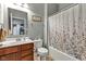 Functional bathroom with wooden vanity, mirror, toilet, and tiled shower-tub combo at 4809 Ozark Ln, Indianapolis, IN 46239