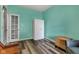 Bright blue room featuring wood-look vinyl flooring and a white storage cabinet at 4809 Ozark Ln, Indianapolis, IN 46239