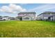 Home's backyard features an open grass area, covered patio, and neighborhood views at 4844 Morenci Ct, New Palestine, IN 46163