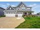 Charming two-story home featuring a three-car garage, well-manicured lawn, and inviting brick-accented porch at 4844 Morenci Ct, New Palestine, IN 46163