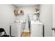 Clean laundry room with white appliances, wood-look floor, and wire shelf for storage at 4844 Morenci Ct, New Palestine, IN 46163
