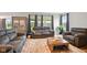 Comfortable living room with plush seating, large windows, neutral tones, and views of a landscaped exterior at 4844 Morenci Ct, New Palestine, IN 46163