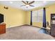 Bedroom featuring neutral carpet, large window, ceiling fan, and bright yellow walls at 4857 Silverbell Dr, Plainfield, IN 46168