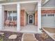 Inviting covered porch with brick accents, white columns, and comfortable seating area at 4857 Silverbell Dr, Plainfield, IN 46168