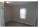 This small bedroom offers neutral carpeting and a view of the private backyard at 509 N Emerson Ave, Indianapolis, IN 46219