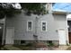 Rear exterior view of the house with vinyl siding, two doors and two basement windows at 509 N Emerson Ave, Indianapolis, IN 46219