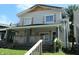 Two-story home with covered porch, wood railings, gray siding, and decorative shutters at 509 N Emerson Ave, Indianapolis, IN 46219