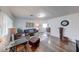 Bright living room with hardwood floors, a cozy leather sofa, and direct access to dining area at 517 S 4Th Ave, Beech Grove, IN 46107