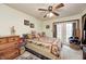 Comfortable bedroom featuring patterned bedding, dresser, ceiling fan and access to natural light for a peaceful rest at 5320 S Lick Crk Rd, Morgantown, IN 46160