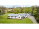 Aerial view of a home with a metal roof, surrounded by a lush green lawn and mature trees at 5320 S Lick Crk Rd, Morgantown, IN 46160