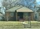 Charming brick home featuring a covered porch, a well-manicured lawn, and easy access with a concrete walkway and steps at 537 N Rural St, Indianapolis, IN 46201