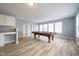 Spacious living room featuring a pool table, built in bookshelves, and wood-look flooring at 5422 Portman Dr, Noblesville, IN 46062