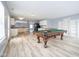 Living room with an open-concept design, featuring a pool table, and a view to the kitchen at 5422 Portman Dr, Noblesville, IN 46062