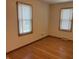 Bedroom featuring hardwood floors, bright windows, and a wall heater at 5822 W 62Nd St, Indianapolis, IN 46278