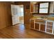 Functional kitchen features retro cabinets, wood floors, and convenient access to other rooms at 5822 W 62Nd St, Indianapolis, IN 46278