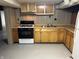 A compact kitchen with ample counter space, black gas range, and wood cabinets at 5822 W 62Nd St, Indianapolis, IN 46278