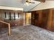 This living room features wood paneled walls, beamed ceiling, and carpet at 5822 W 62Nd St, Indianapolis, IN 46278