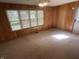 Living room features natural lighting, wood paneled walls, carpet flooring, and ceiling fan at 5822 W 62Nd St, Indianapolis, IN 46278