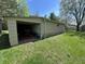 Exterior of shed in yard, featuring an open garage door and tractor inside at 5822 W 62Nd St, Indianapolis, IN 46278