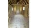 Unfinished interior of shed, featuring wood walls, plywood flooring, and two windows at 5822 W 62Nd St, Indianapolis, IN 46278