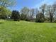 Expansive green yard with blooming flowers and mature trees at 5822 W 62Nd St, Indianapolis, IN 46278