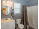 Bathroom featuring a single vanity, a round mirror, and a shower with a patterned curtain at 5982 Blue Heron Way, Plainfield, IN 46168